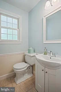 a bathroom with a sink toilet and window