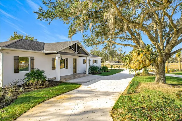 an empty room with wooden floor fireplace and windows