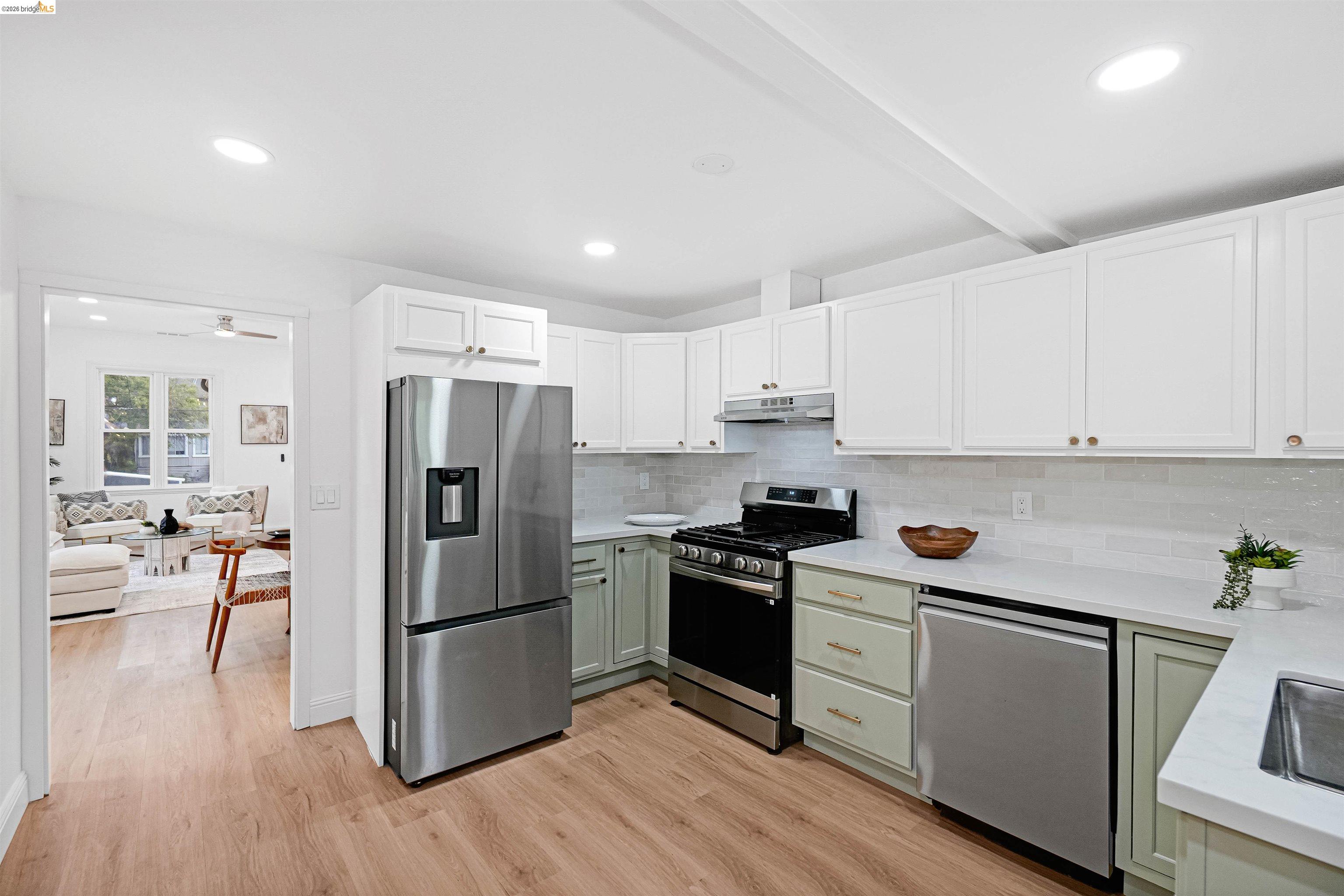 1812 Woolsey Street Berkeley, CA 94703 - Photo 12 of 48 Modern kitchen featuring wood-finish flooring, white upper cabinetry, and light green lower cabinetry