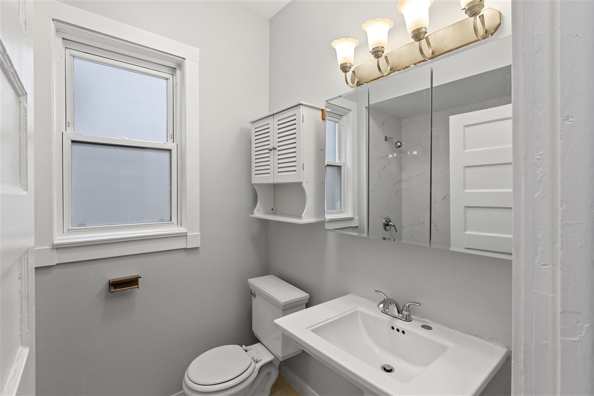 3716 North Wayne Avenue, Unit 2 Chicago, IL 60613 - Photo 14 of 17 a bathroom with a toilet sink and mirror