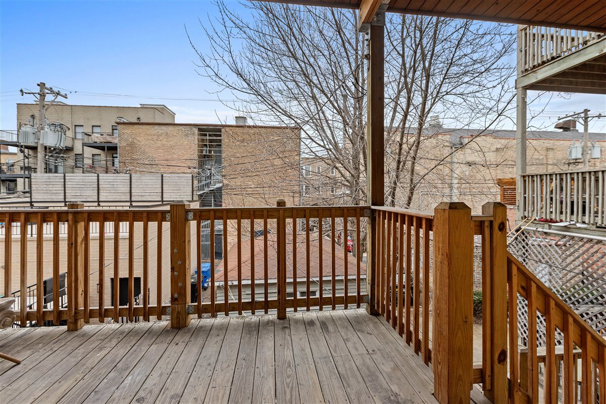 3716 North Wayne Avenue, Unit 2 Chicago, IL 60613 - Photo 16 of 17 a view of balcony with wooden floor and fence