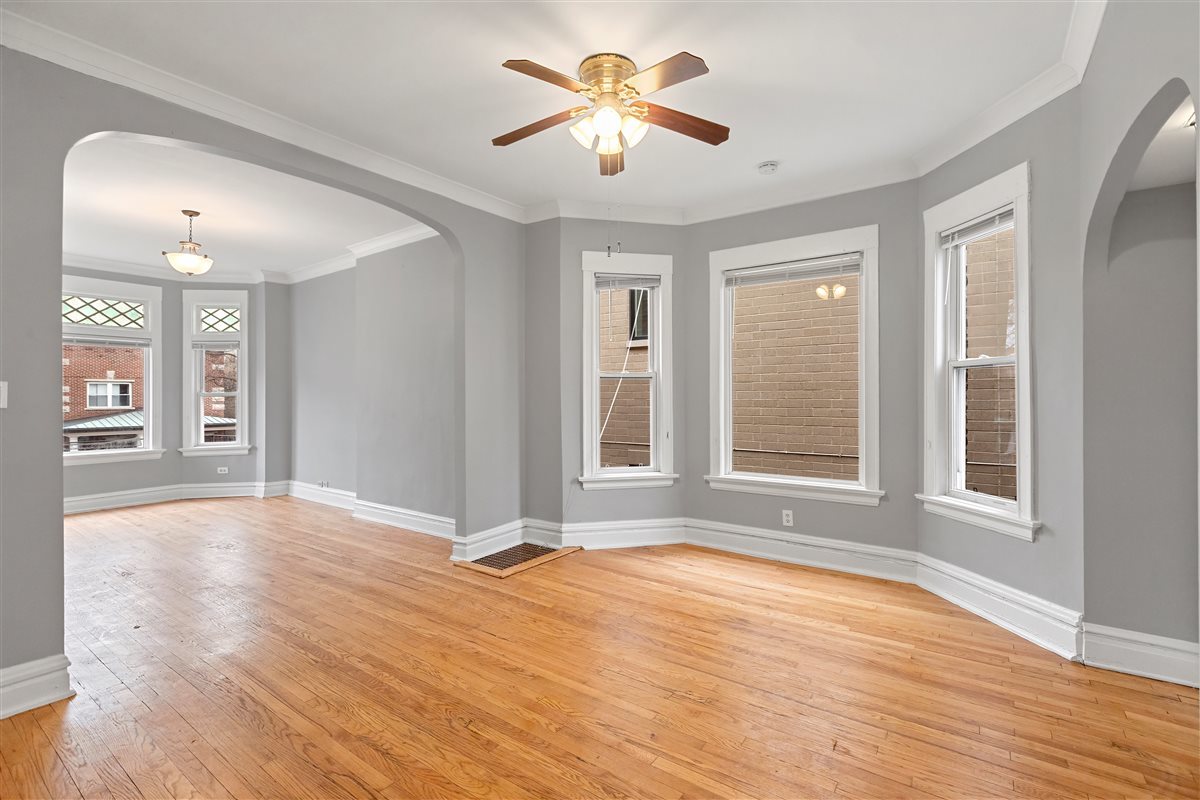 3716 North Wayne Avenue, Unit 2 Chicago, IL 60613 - Photo 5 of 17 a view of an empty room with window and wooden floor