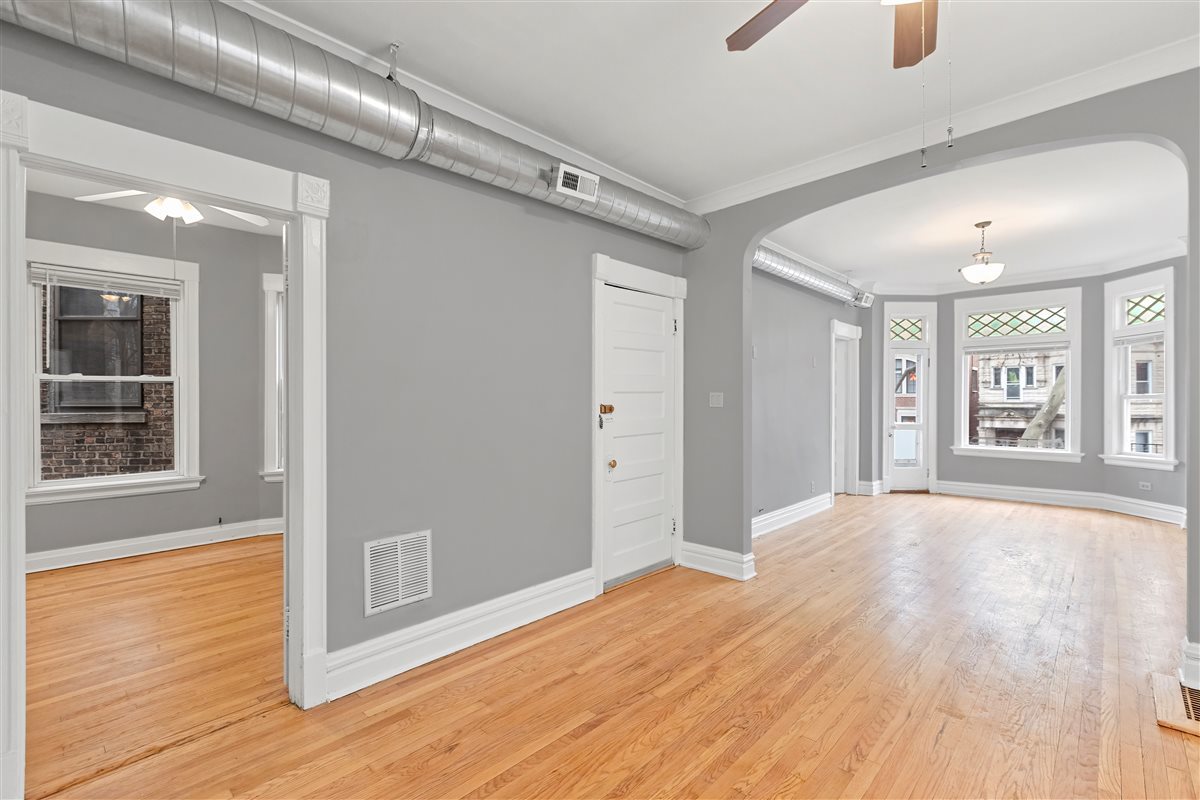 3716 North Wayne Avenue, Unit 2 Chicago, IL 60613 - Photo 6 of 17 a view of an empty room with wooden floor and a window
