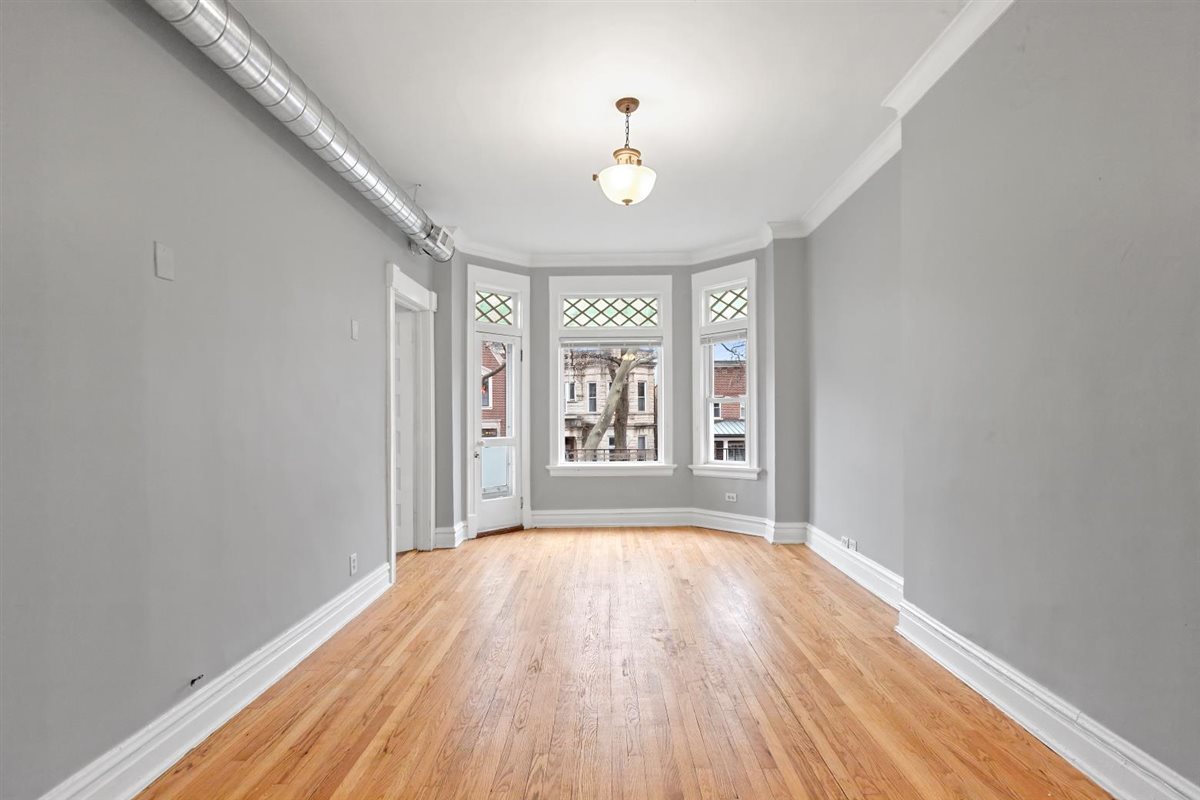 3716 North Wayne Avenue, Unit 2 Chicago, IL 60613 - Photo 7 of 17 wooden floor in an empty room with a window