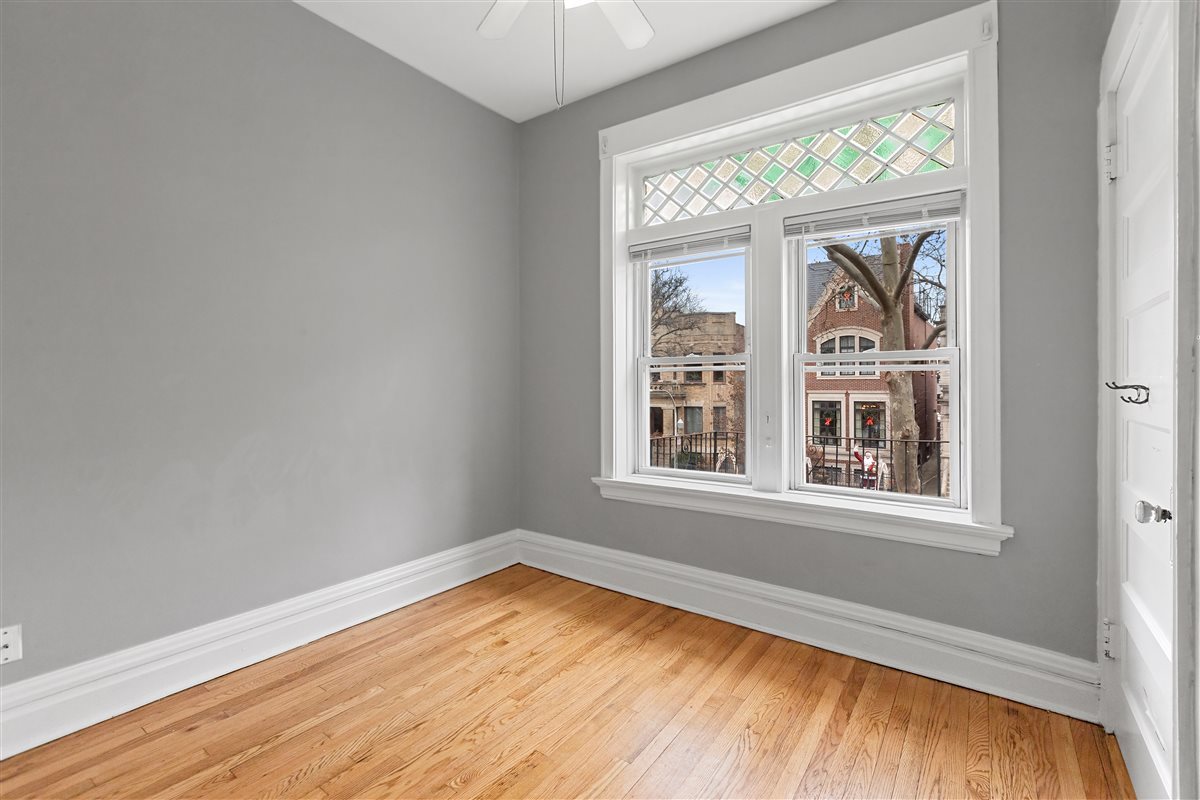 3716 North Wayne Avenue, Unit 2 Chicago, IL 60613 - Photo 8 of 17 an empty room with wooden floor and windows