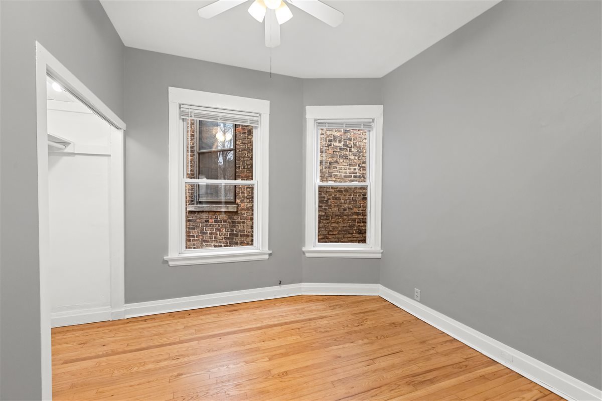 3716 North Wayne Avenue, Unit 2 Chicago, IL 60613 - Photo 9 of 17 a view of an empty room with wooden floor and a window