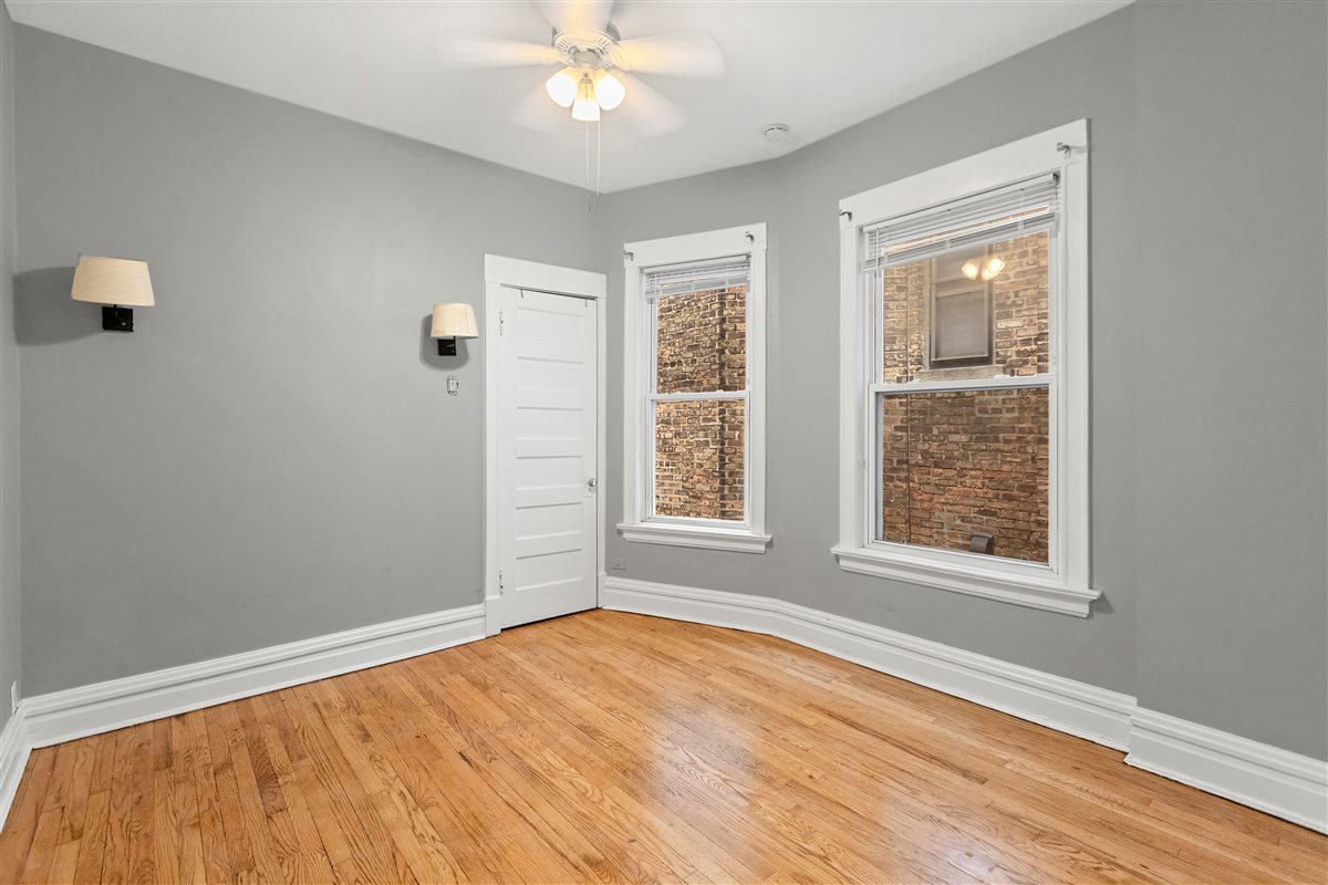 3716 North Wayne Avenue, Unit 2 Chicago, IL 60613 - Photo 10 of 17 a view of an empty room with wooden floor and a window