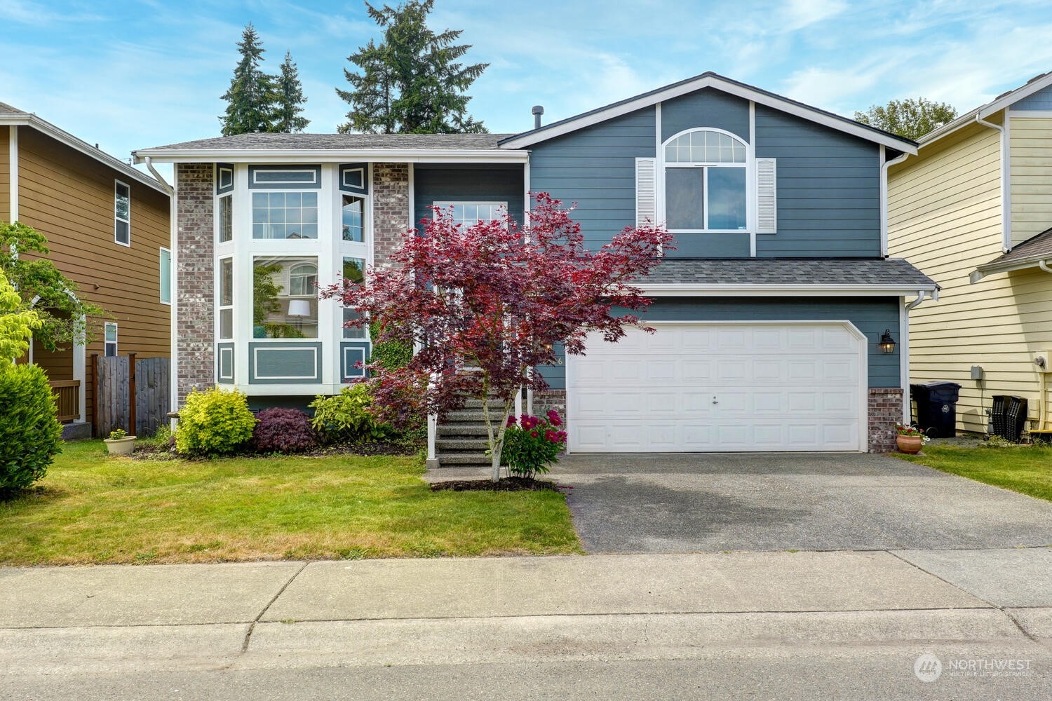 a front view of a house with a yard and garage