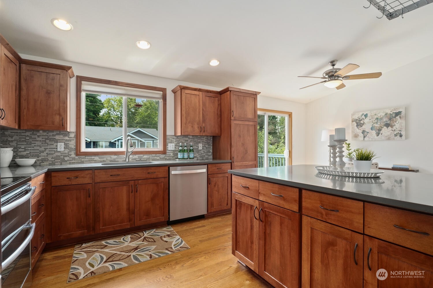 1326 238th Place Southwest Bothell, WA 98021 - Photo 11 of 34 a kitchen with stainless steel appliances granite countertop wooden cabinets a stove a sink and a large window