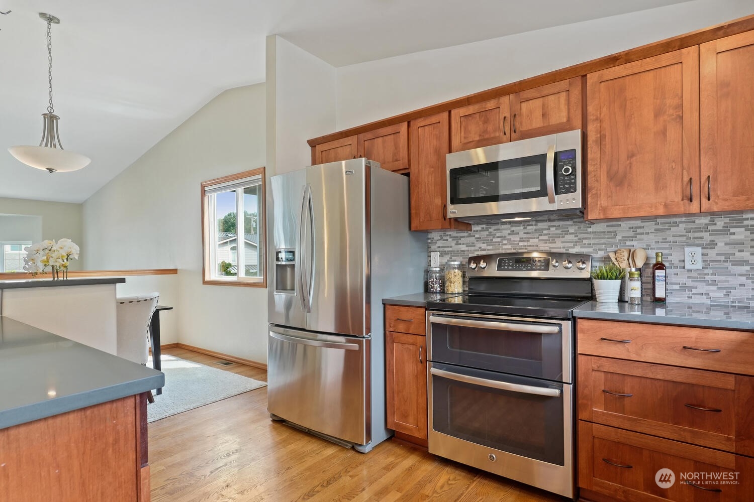 1326 238th Place Southwest Bothell, WA 98021 - Photo 12 of 34 a kitchen with granite countertop wooden floors and stainless steel appliances