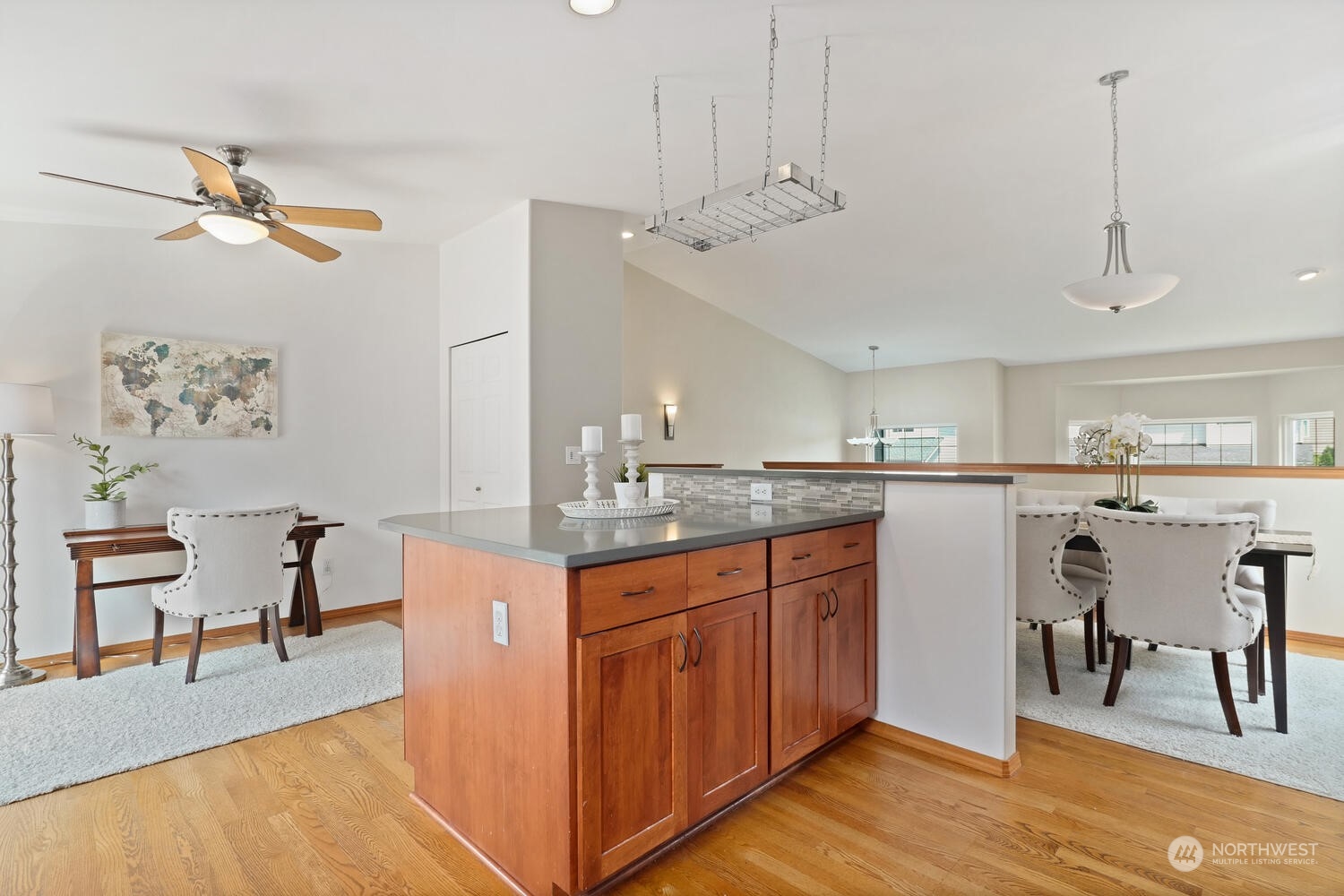 1326 238th Place Southwest Bothell, WA 98021 - Photo 13 of 34 a kitchen with kitchen island granite countertop a table chairs a sink dishwasher window and cabinets