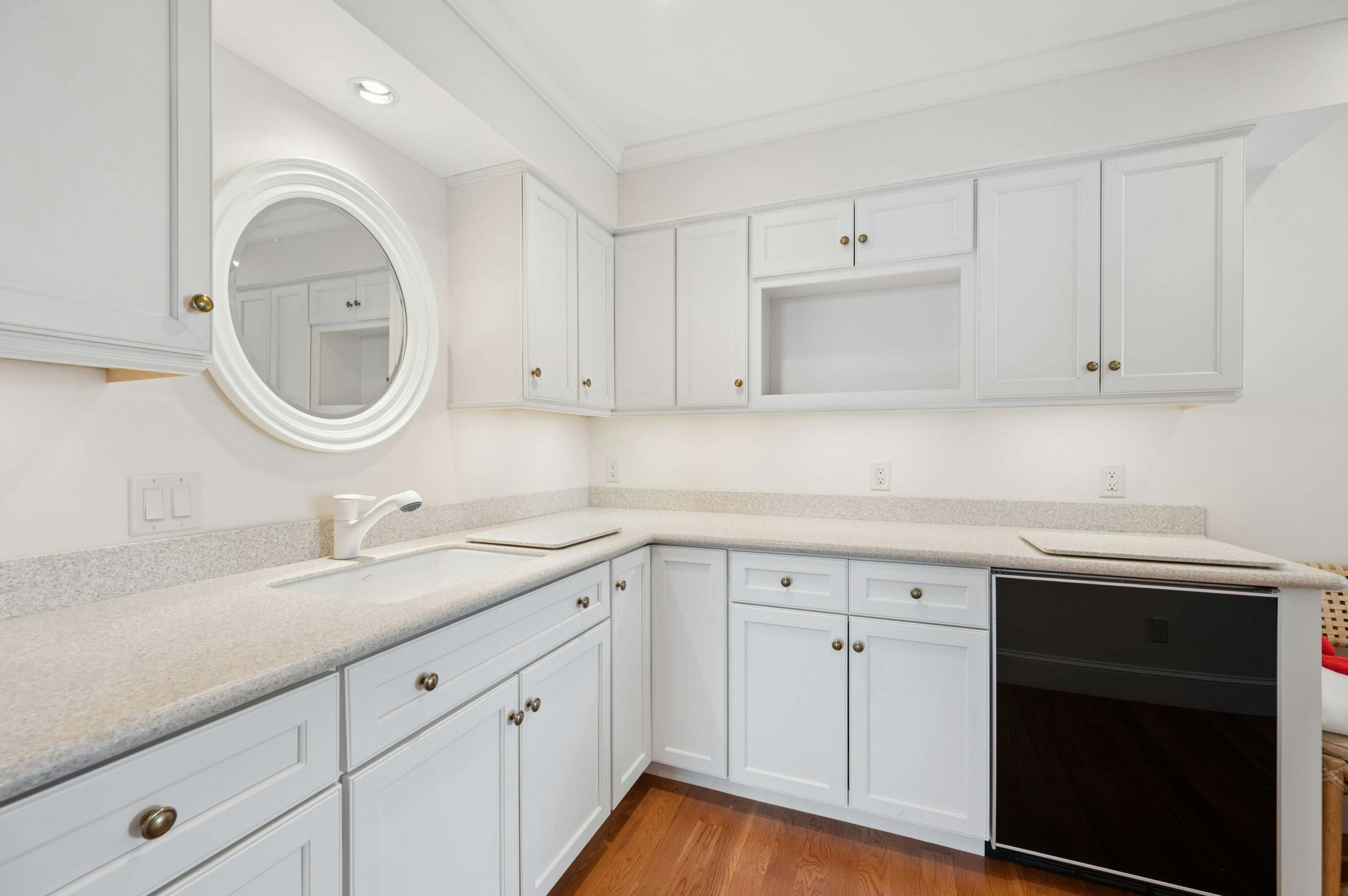 23 Snow Inn Road, Unit 7 Harwich Port, MA 02646 - Photo 30 of 37 a kitchen with white cabinets a sink and dishwasher