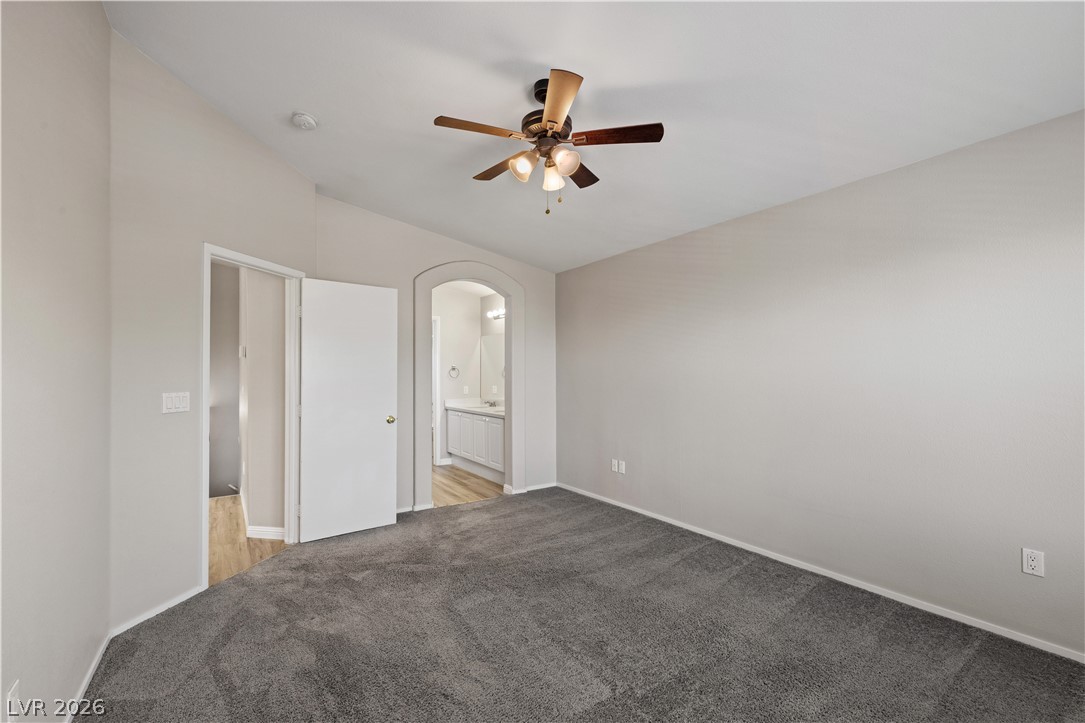 8777 Roping Rodeo Avenue, Unit 101 Las Vegas, NV 89178 - Photo 13 of 25 Comfortable carpeting and a ceiling fan create a relaxing atmosphere in this primary bedroom suite.