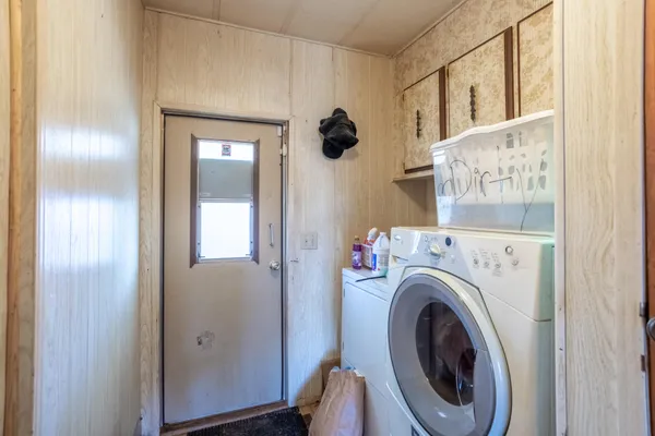 a view of backyard with swimming pool and seating space