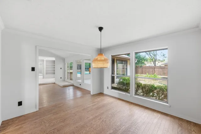 a view of a living room with hardwood floor ceiling fan and window