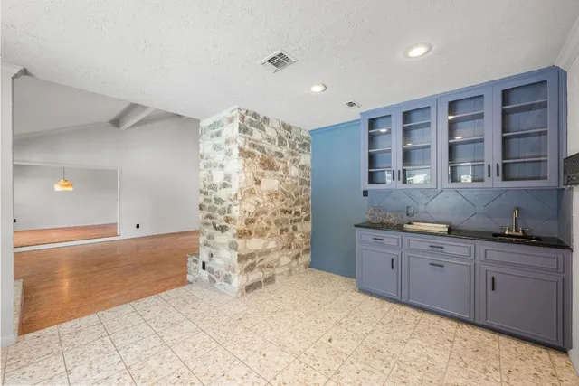 a kitchen with granite countertop a stove a sink and a refrigerator