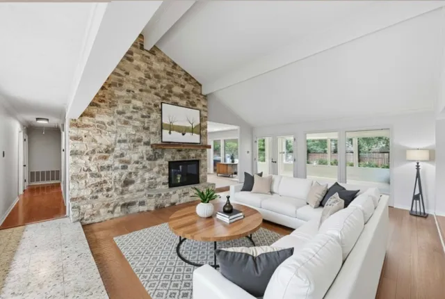 a living room with furniture large window and a fireplace