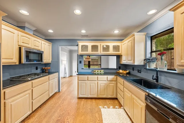 a large kitchen with stainless steel appliances granite countertop a sink and cabinets