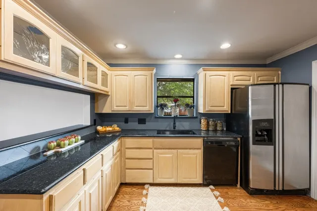 a kitchen with stainless steel appliances granite countertop a refrigerator a sink a stove and island