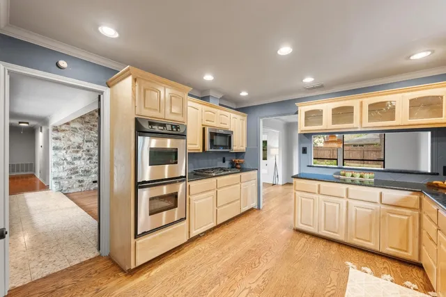 a kitchen with stainless steel appliances granite countertop a refrigerator and stove top oven