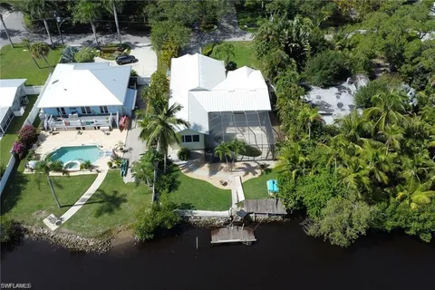 an aerial view of a house with a yard and lake view