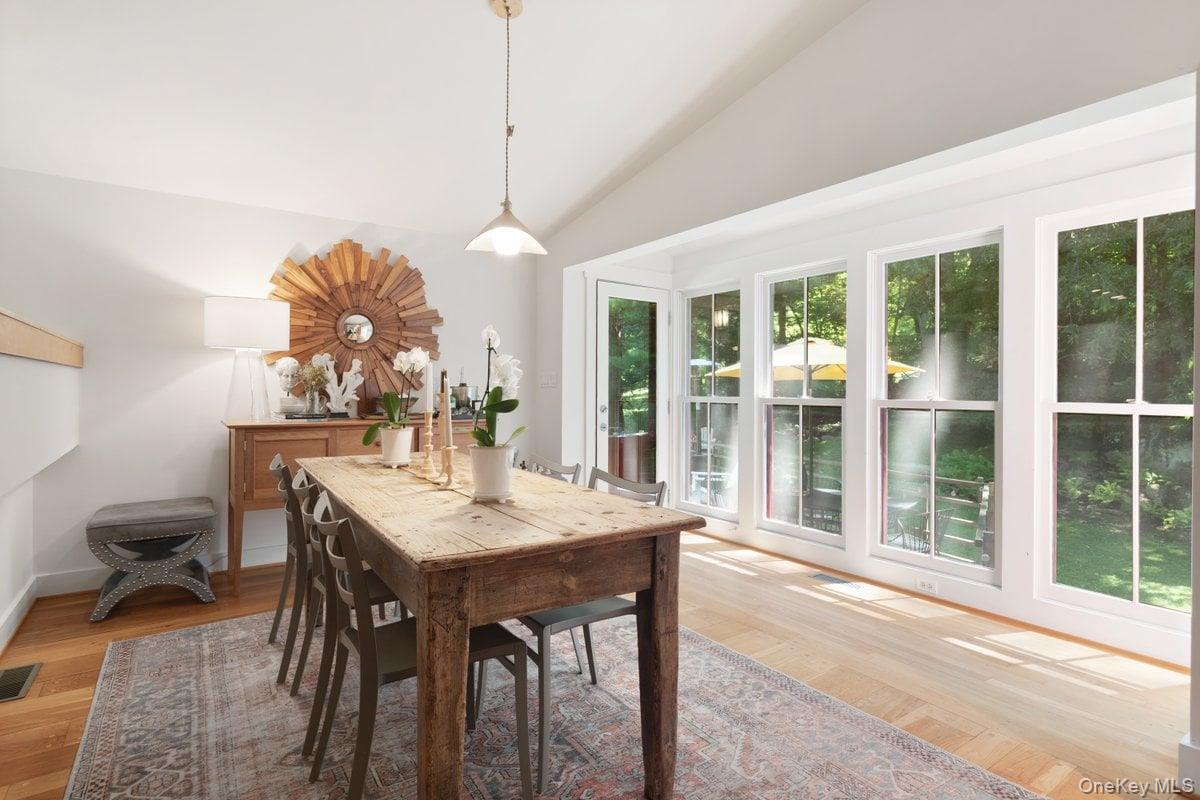 1821 Spring Valley Road Ossining, NY 10562 - Photo 19 of 48 A wall of windows anchors the dining room, filling the space with natural sunlight and offering serene backyard views. A glass door provides access to the deck, making indoor-outdoor living effortless.