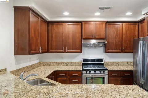 a kitchen with stainless steel appliances granite countertop a stove and a sink