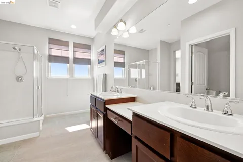 a bathroom with a double vanity sink a mirror and a shower