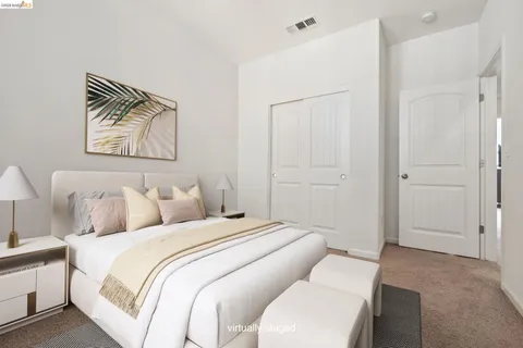 a bedroom with a bed and a painting on the wall