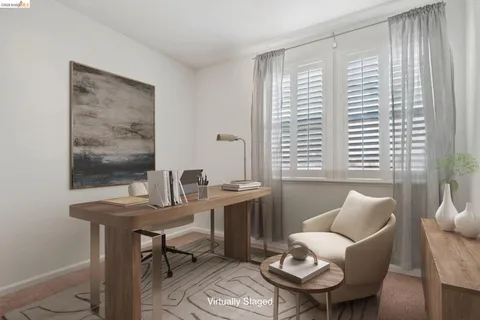 a view of a workspace with furniture and a window