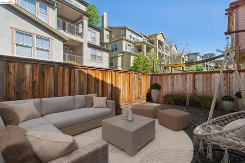 a view of a patio with couches and a table and chairs with wooden fence