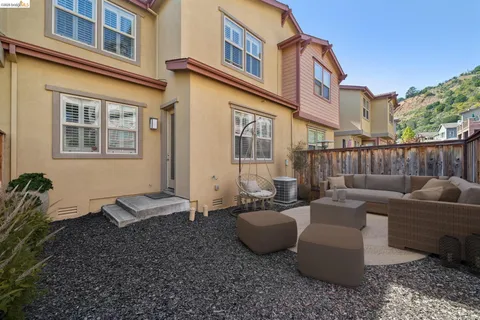 a view of a patio with couches table and chairs and potted plants