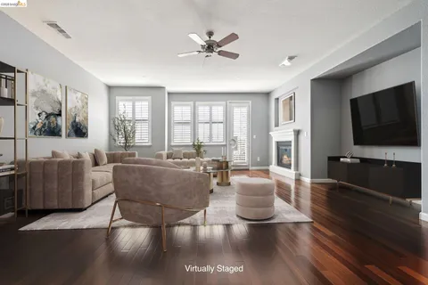 a living room with furniture a flat screen tv and a large window