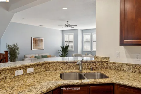 a kitchen with granite countertop a sink a stove and cabinets