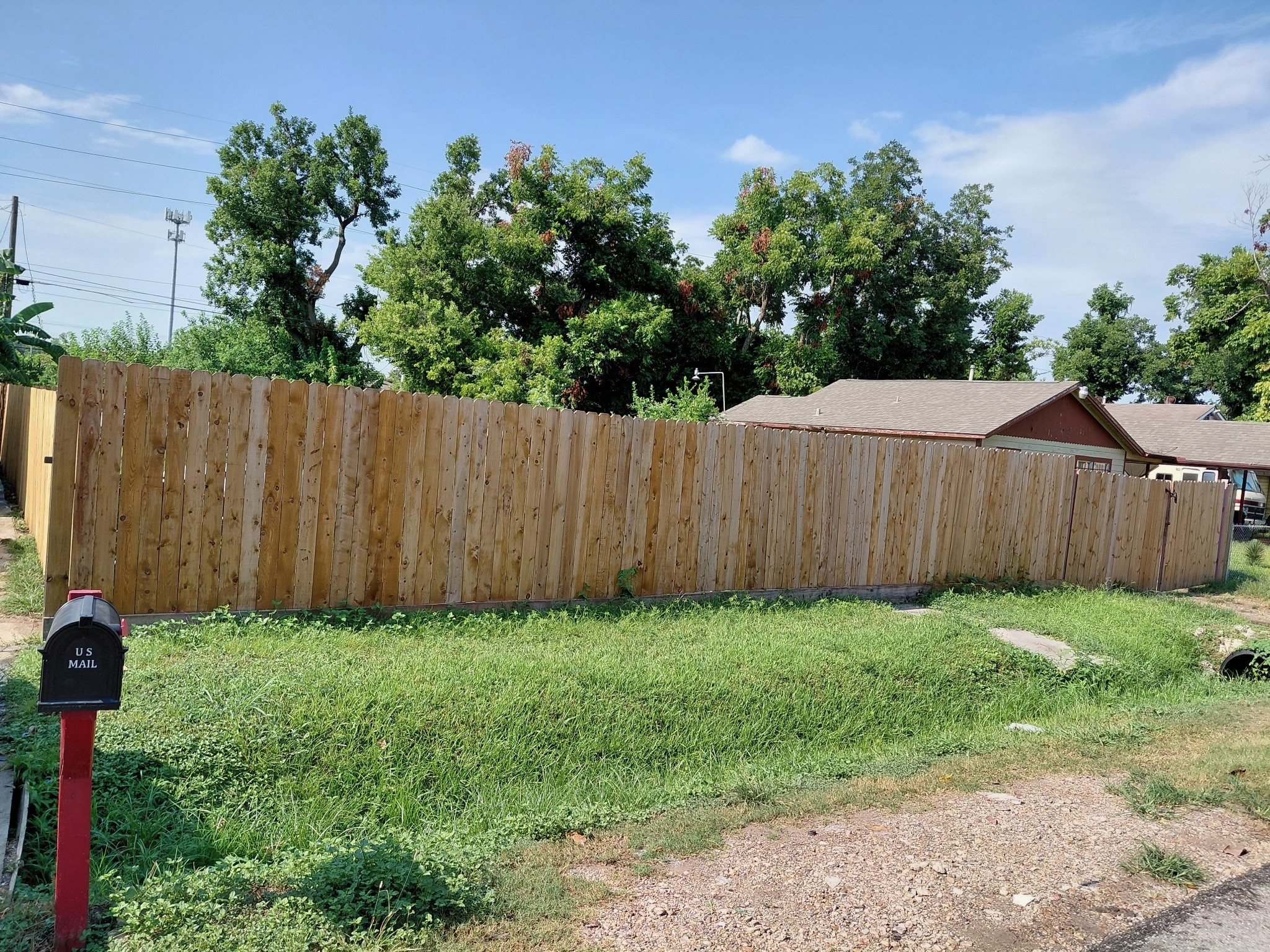 a view of a backyard with wooden fence