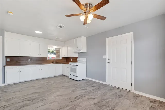 a kitchen with a refrigerator and white cabinets