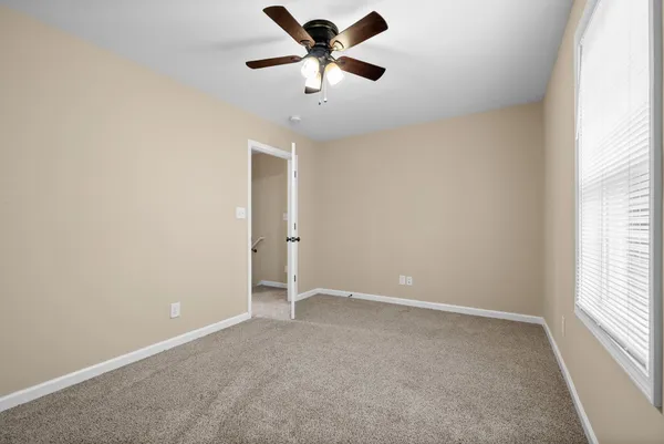 an empty room with a window and a fan