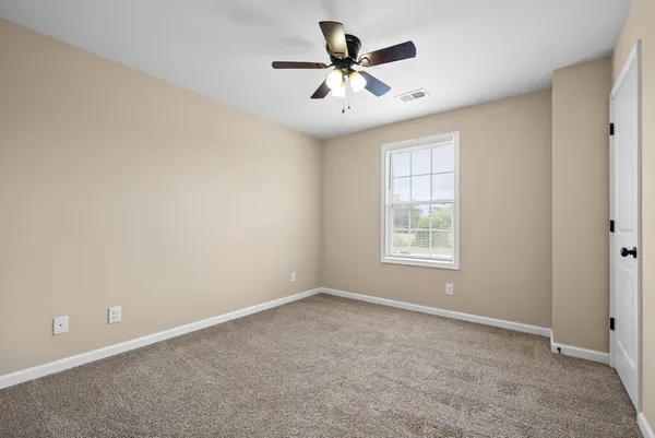 a view of a livingroom with a ceiling fan and window