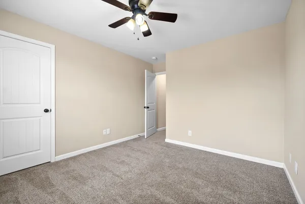 an empty room with a fan and a window