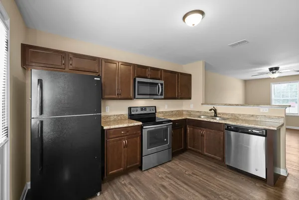 a kitchen with stainless steel appliances granite countertop a stove refrigerator sink and microwave
