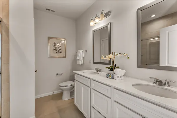 a bathroom with a granite countertop sink mirror and toilet
