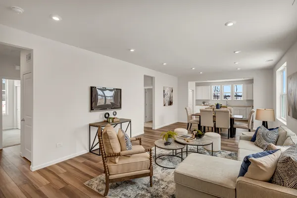 a living room with furniture a wooden floor and white walls
