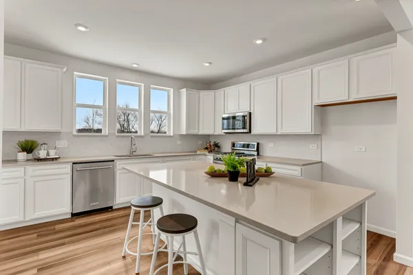 a kitchen with a sink a window and chairs