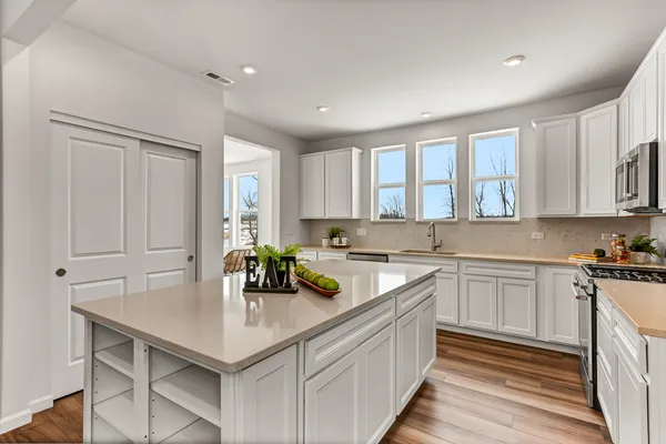 a kitchen with a sink a window and cabinets