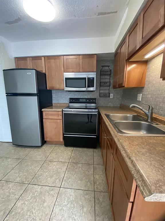 21150 Gertrude Avenue, Unit R1 Port Charlotte, FL 33952 - Photo 15 of 18 a kitchen with a sink and a refrigerator