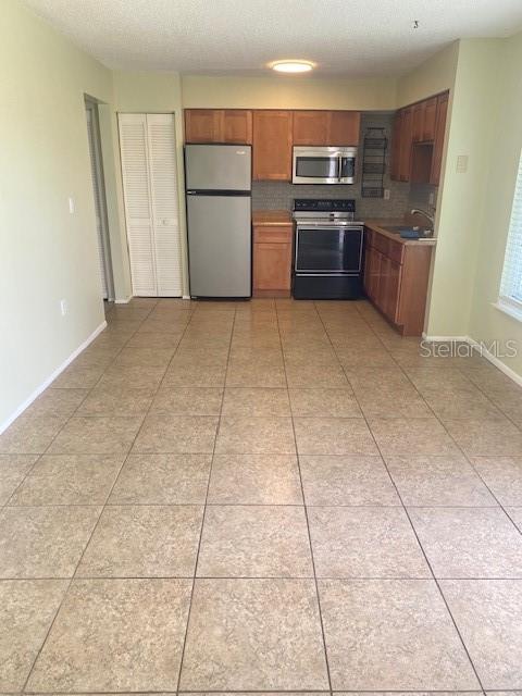 21150 Gertrude Avenue, Unit R1 Port Charlotte, FL 33952 - Photo 7 of 18 a kitchen with granite countertop a refrigerator and a stove