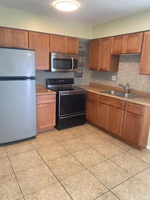 21150 Gertrude Avenue, Unit R1 Port Charlotte, FL 33952 - Photo 8 of 18 a kitchen with stainless steel appliances granite countertop a refrigerator sink and microwave