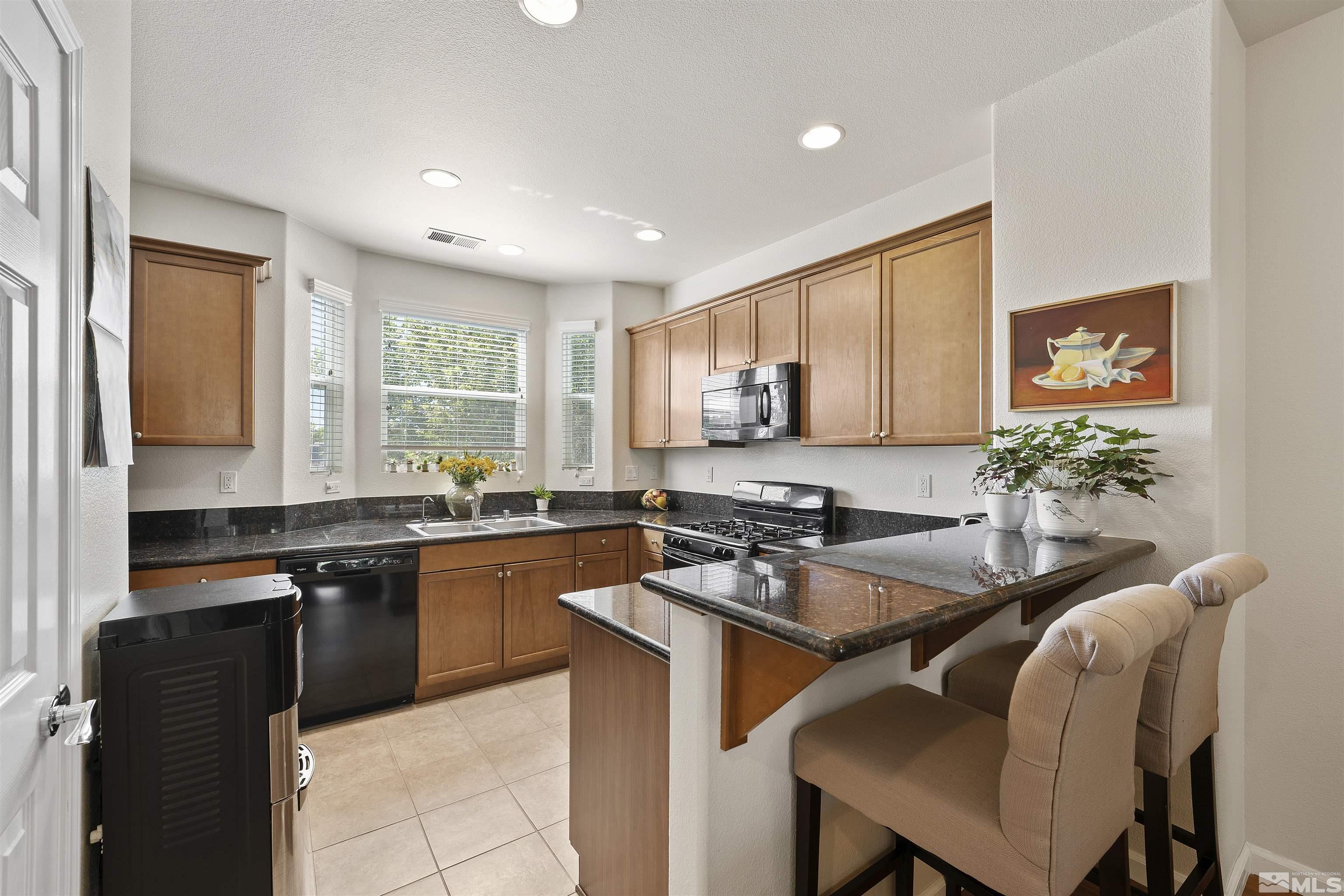 2212 Grosvenor Reno, NV 89509 - Photo 16 of 36 a kitchen with granite countertop a stove a sink a dining table and chairs
