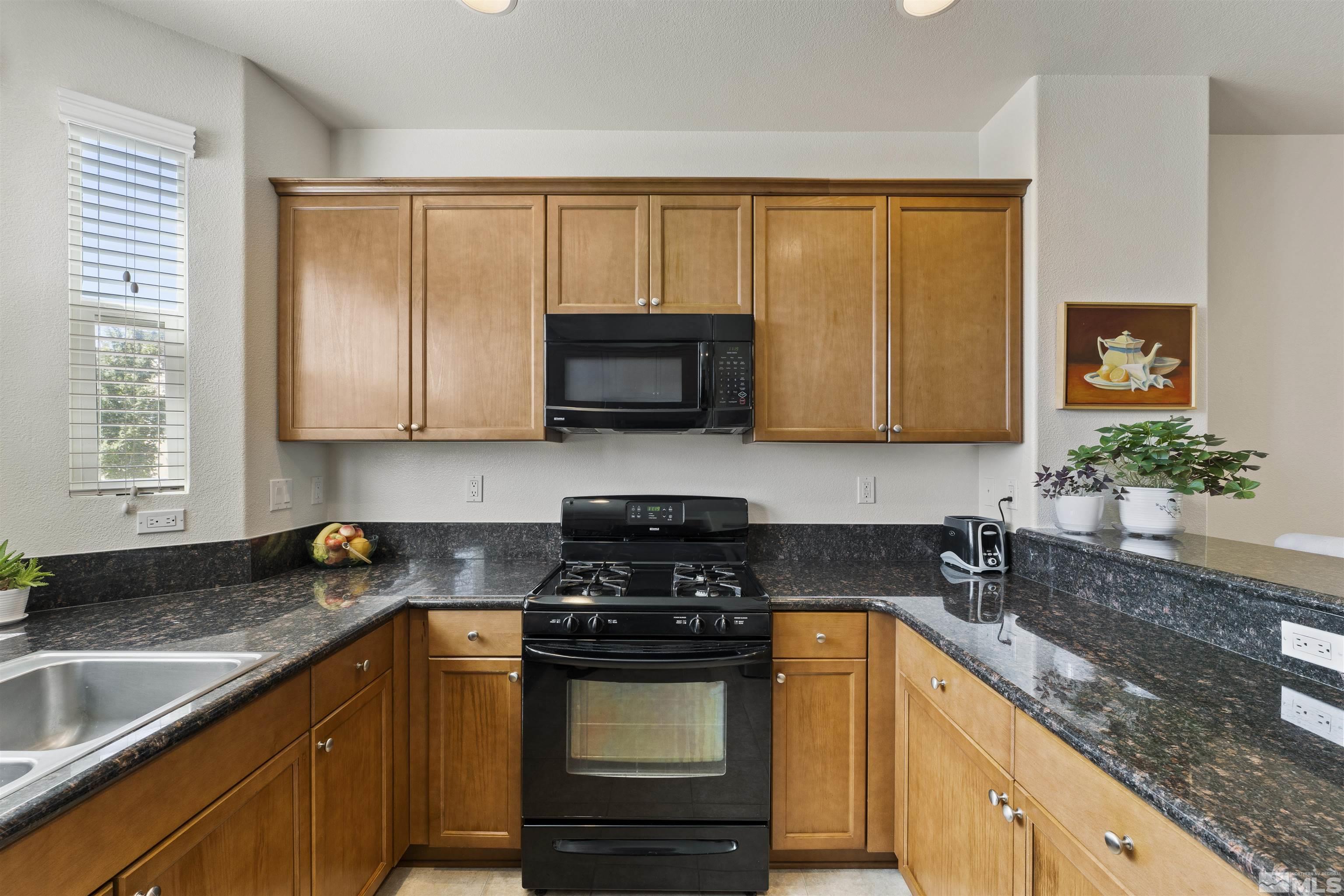 2212 Grosvenor Reno, NV 89509 - Photo 18 of 36 a kitchen with stainless steel appliances granite countertop wooden cabinets and a stove top oven