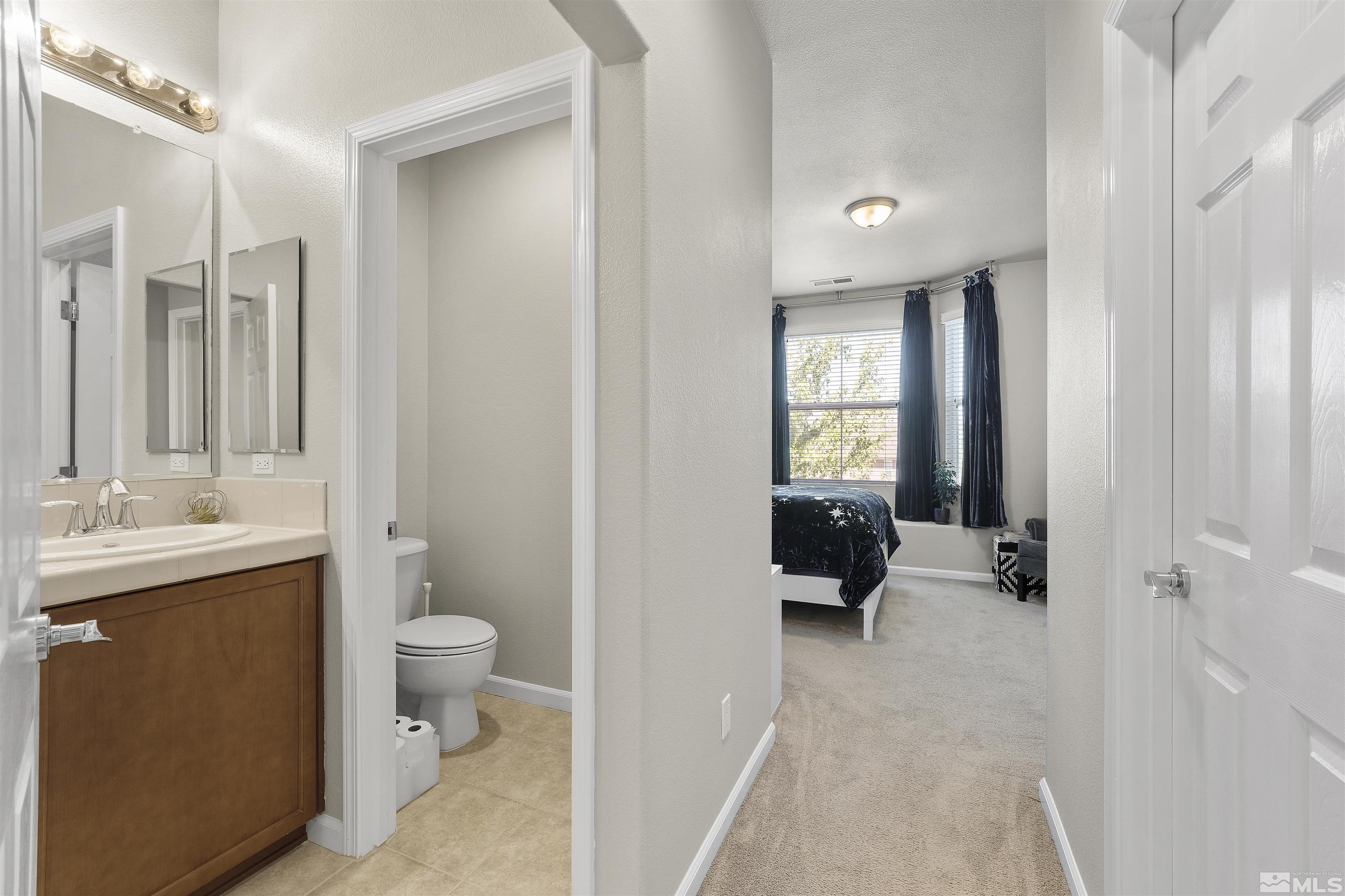 2212 Grosvenor Reno, NV 89509 - Photo 28 of 36 a bathroom with a toilet a sink and mirror